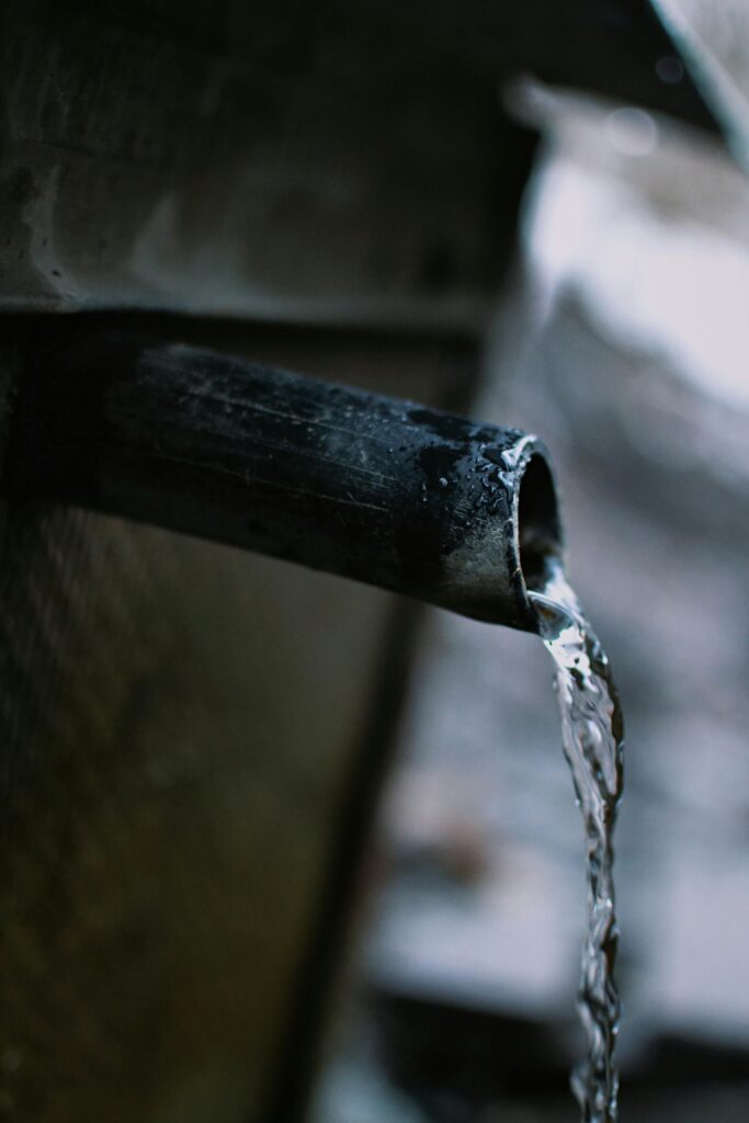 pexels-photo-11370711-11370711 Flowing water from metal pipe showcasing motion and fluidity in an industrial setting.